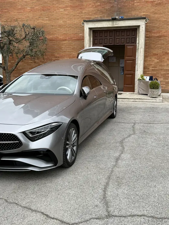Auto funebre Mercedes davanti all'ingresso della chiesa durante un servizio
